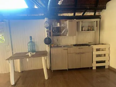 a kitchen with a table with a bottle on it at Punta Arena EcoHostal & EcoFit in Playa Punta Arena