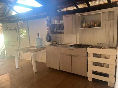a kitchen with a table and a stove top oven at Punta Arena EcoHostal & EcoFit - Your Eco-Conscious Oasis in Cartagena de Indias