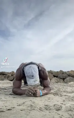 a man laying on the sand on the beach at Punta Arena EcoHostal & EcoFit - Your Eco-Conscious Oasis in Cartagena de Indias