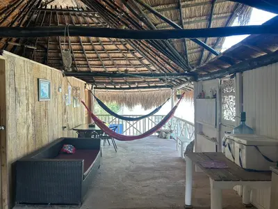 a hammock in a hut with a hammock in it at Punta Arena EcoHostal & EcoFit 01 in Playa Punta Arena