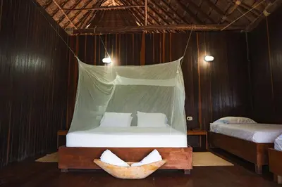 a bedroom with a bed with a hanging bedvisor at U-GO Espectacular Casa en Barú con Vistas al Mar in Cartagena de Indias