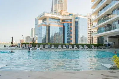 a swimming pool with chairs and people in a city at U-GO Morros City Bocagrande Frente al Mar in Cartagena de Indias