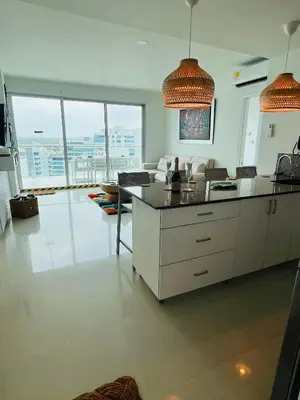 a kitchen with a counter and a living room with windows at Cartagena in Cartagena de Indias