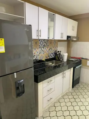 a kitchen with white cabinets and a stainless steel refrigerator at Apartahotel Edificio Baquero x5 Apto 401 in Barranquilla