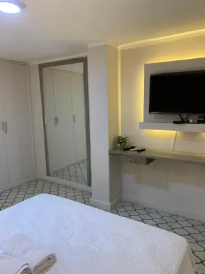 a bedroom with a bed and a flat screen tv at Apartahotel Edificio Baquero x5 Apto 401 in Barranquilla
