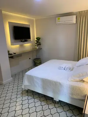 a bedroom with a bed with a tv on the wall at Apartahotel Edificio Baquero x5 Apto 401 in Barranquilla