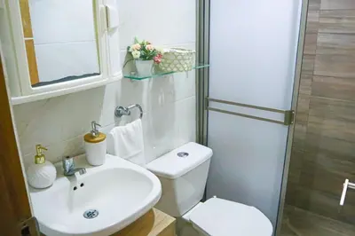 a white bathroom with a toilet and a sink at Apartamento Arenita de mar in Coveñas