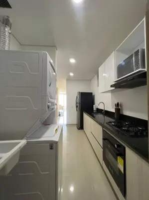 a white kitchen with a stove and a refrigerator at Moderno y amplio apartamento cerca a la playa! in Cartagena de Indias