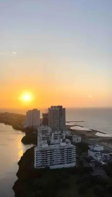 a view of a city with the sun setting over the ocean at Moderno y amplio apartamento cerca a la playa! in Cartagena de Indias