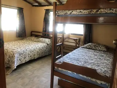 a bedroom with two bunk beds and a table at SiÉ Cabaña en Coveñas cerca a la playa in Coveñas