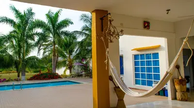 a house with a slide next to a swimming pool at Hotel - Granja de Animales San Basilio de Palenque in San Basilio del Palenque