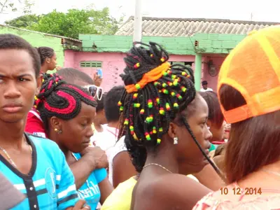 a group of children standing around a woman with dreadlocks at Hotel - Granja de Animales San Basilio de Palenque in San Basilio del Palenque