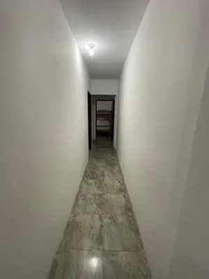 a hallway with white walls and a tile floor at Apartamentos Poseidon in Coveñas