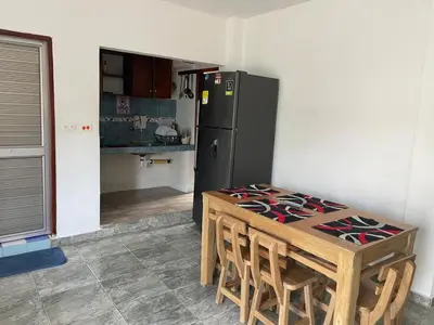 a kitchen with a table and a black refrigerator at Apartamentos Poseidon in Coveñas