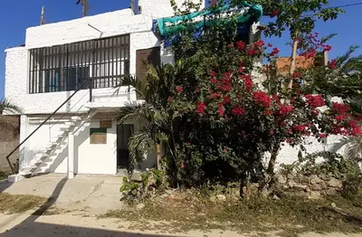 a white building with red flowers in front of it at Hostal Sol in Cartagena de Indias