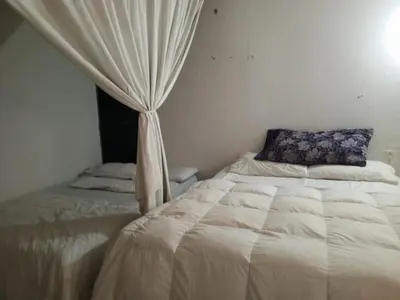 a bedroom with a bed and a window with curtains at Hostal Sol in Cartagena de Indias