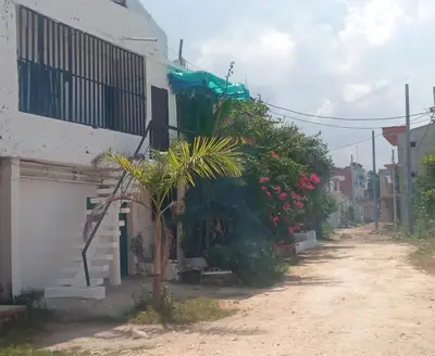 a dirt road next to a white building with plants at Hostal Sol in Cartagena de Indias