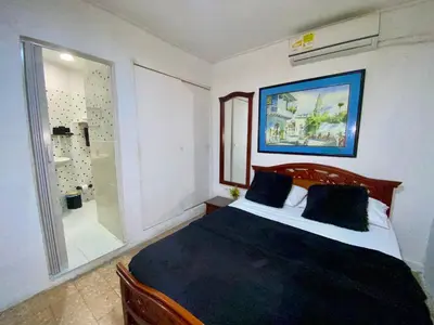 a bedroom with a bed and a glass shower at Habitación Cerca de aeropuerto in Cartagena de Indias