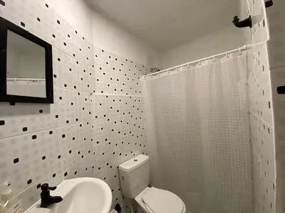 a white bathroom with a toilet and a mirror at Habitación Cerca de aeropuerto in Cartagena de Indias