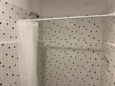 a bathroom with a shower with white tiles at Habitación Cerca de aeropuerto in Cartagena de Indias