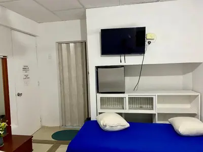 a room with a blue bed and a flat screen tv at Habitación Multiple cerca de aeropuerto in Cartagena de Indias