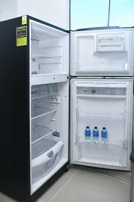 an open refrigerator with bottles of water in it at Excelente ubicación y cómodo apto, perfecto para ti! in Barranquilla