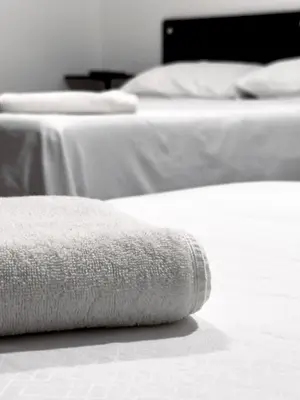 two beds with white sheets and towels on them at Hotel bazurto plaza in Cartagena de Indias