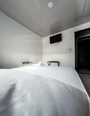 a bedroom with a large white bed and a flat screen tv at Hotel bazurto plaza in Cartagena de Indias