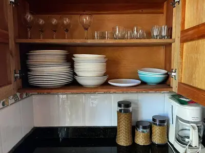 a kitchen cabinet with plates and bowls and glasses at Casa finca Santiago Tolú in Altamira