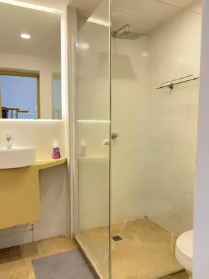 a glass shower in a bathroom with a sink and a toilet at Casa Zaguan in Cartagena de Indias