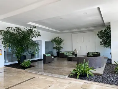 a lobby with tables and chairs and potted plants at Apartamento playa Morros, La boquilla, Cartagena de indias in Cartagena de Indias