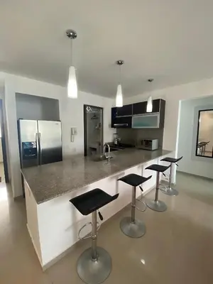 a kitchen with four bar stools and a counter top at Apartamento playa Morros, La boquilla, Cartagena de indias in Cartagena de Indias