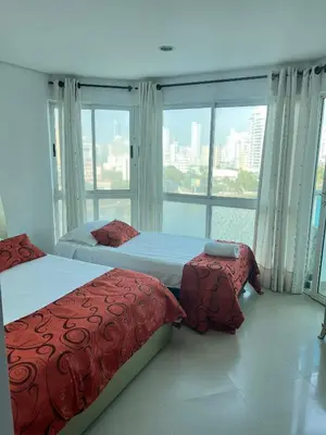 two beds in a room with a large window at Torres del lago de 3 habitaciones in Cartagena de Indias