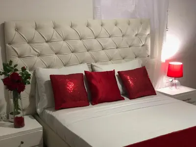 a white bed with two red pillows and a red lamp at Hotel Platinum Luxury in Barranquilla