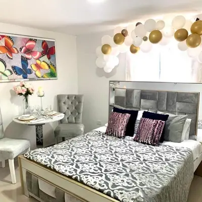 a bedroom with a bed with a table and balloons at Hotel Platinum Luxury in Barranquilla