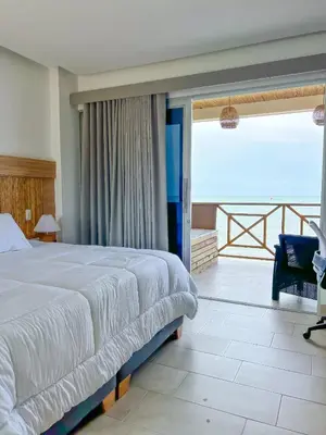 a bedroom with a large bed and a balcony at Apartamento - suite, Frente al mar in San Silvestre