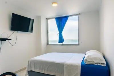 a bedroom with a bed with a window and a television at Acogedor Apartaestudio Laguito 1 Habitacion N4A1 in Cartagena de Indias