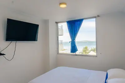 a bedroom with a window with a view of the ocean at Acogedor Apartaestudio Laguito 1 Habitacion N4A1 in Cartagena de Indias