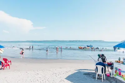 a beach with a bunch of people in the water at Acogedor Apartaestudio Laguito 1 Habitacion N4A1 in Cartagena de Indias