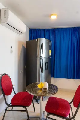 a table with chairs and a refrigerator in a room at Acogedor Apartaestudio Laguito 1 Habitacion N4A1 in Cartagena de Indias