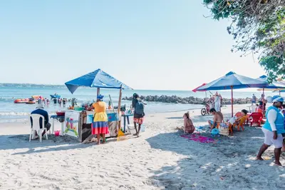 a group of people on a beach with umbrellas at Acogedor Apartaestudio Laguito 1 Habitacion N4A1 in Cartagena de Indias