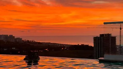 a couple in a infinity pool with a sunset at Dominique in Cartagena de Indias