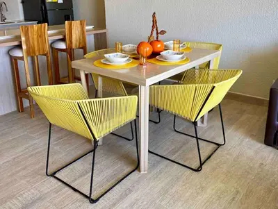 a table with yellow chairs and a table with a pumpkin on it at Dominique in Cartagena de Indias