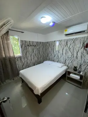 a bedroom with a white bed in a room at Hotel Rancho Grande in Barranquilla