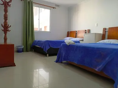 a room with two beds and a window at Hotel Palma Real Cartagena in Cartagena de Indias
