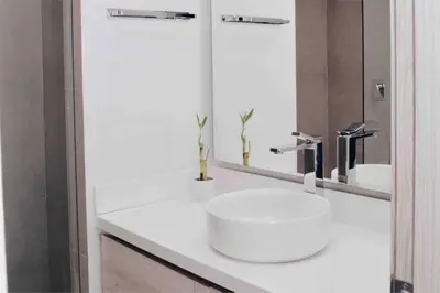 a white bathroom with a sink and a mirror at Lujoso Penthouse - Vista al Mar - Playa Privada in Cartagena de Indias