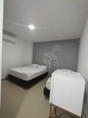 a room with two beds and a white wall at HOTEL BELLAMAR in Cartagena de Indias
