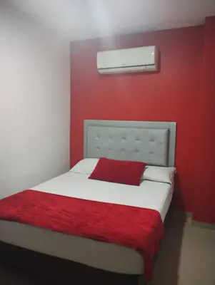 a red bedroom with a white bed with a red wall at HOTEL BELLAMAR in Cartagena de Indias
