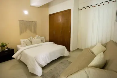 a bedroom with a white bed and a couch at Un espacio sofisticado en medio de El Laguito Edificio Poseidon del Caribe in Cartagena de Indias