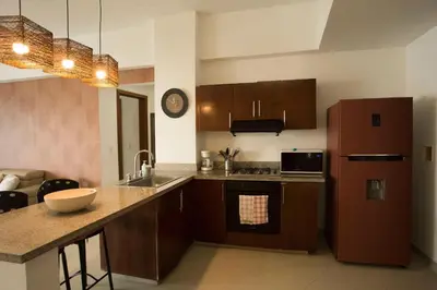 a kitchen with a refrigerator and a counter top at Un espacio sofisticado en medio de El Laguito Edificio Poseidon del Caribe in Cartagena de Indias